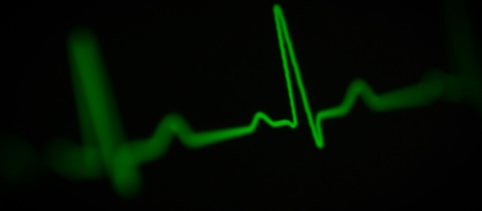 a green heart beat on a black background