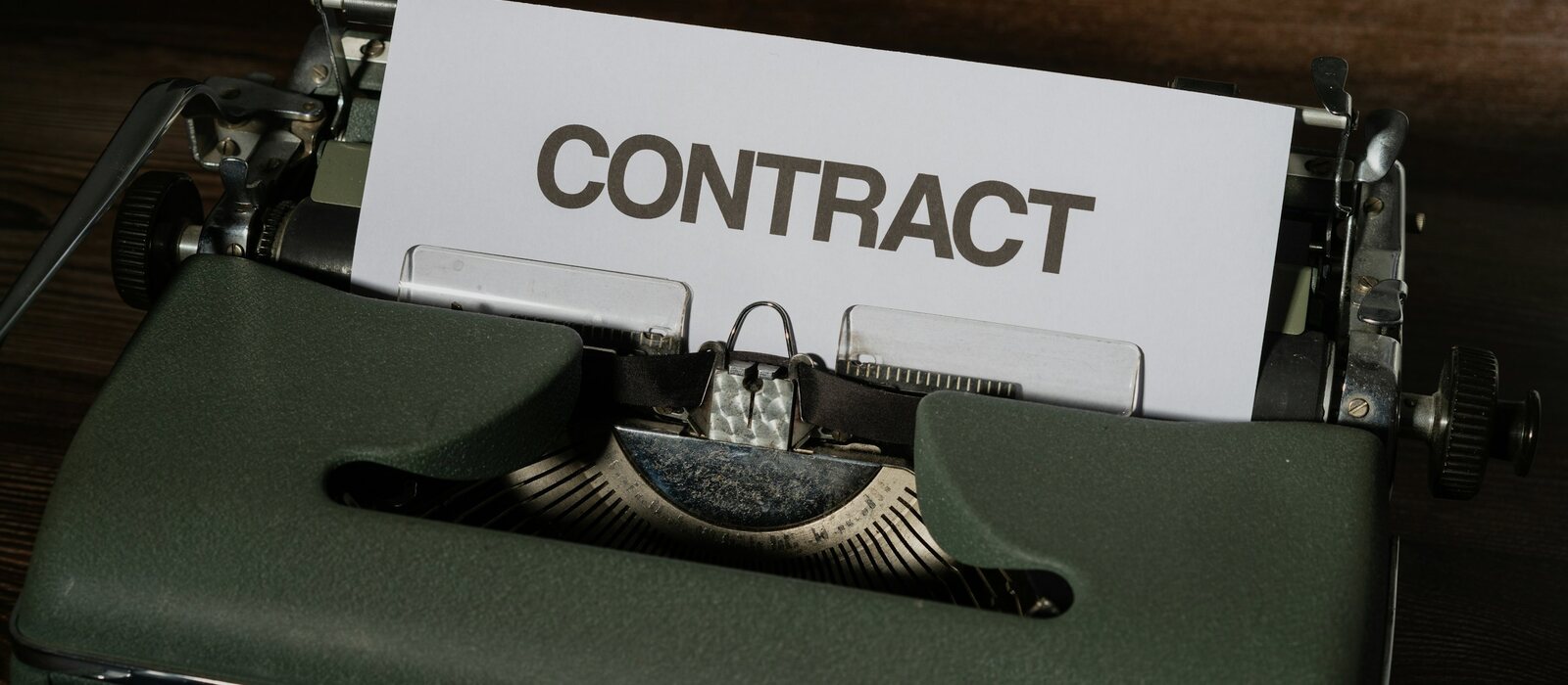 a close up of a typewriter with a sign that reads contact